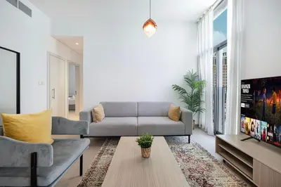 a living room with a couch and a tv at Restay Homes - Fancy 2BR in Belgravia Heights - Pool access in Dubai