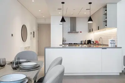 a kitchen with a table and chairs and a counter at Restay Homes - Fancy 2BR in Belgravia Heights - Pool access in Dubai