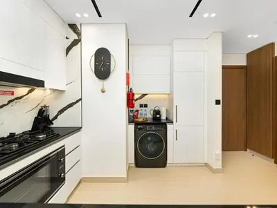 a kitchen with a stove and a clock on the wall at Chic 1BR Burj Khalifa Views Private Jacuzzi in Dubai