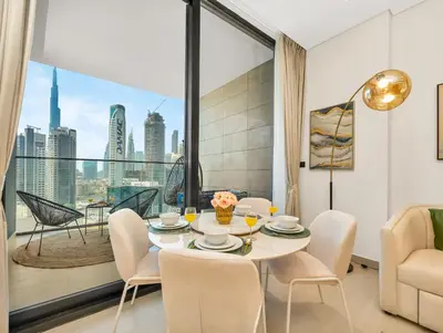 a dining room with a table and chairs and a large window at Chic 1BR Burj Khalifa Views Private Jacuzzi in Dubai