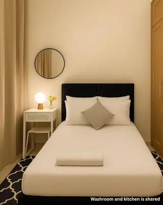 a bedroom with a bed with a mirror and a table at The Manchester JBR Marina Apartment Private Room with shared washroom in Dubai