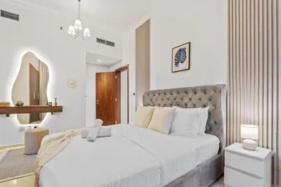 a white bedroom with a large white bed and a mirror at Luxury 1 BR - Walk to Dubai Mall & Burj Khalifa in Dubai