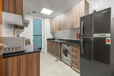 a kitchen with a refrigerator and a washing machine at Luxury 1 BR - Walk to Dubai Mall & Burj Khalifa in Dubai