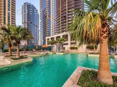 a pool with palm trees and tall buildings at Trident Grand Residence 1 BDR plus Guest Bedroom, Dubai Marina in Dubai