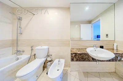 a white bathroom with a toilet and a sink at Trident Grand Residence 1 BDR plus Guest Bedroom, Dubai Marina in Dubai