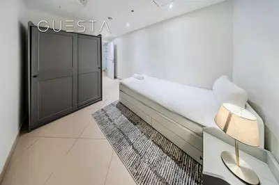 a white room with a bed and a door at Trident Grand Residence 1 BDR plus Guest Bedroom, Dubai Marina in Dubai