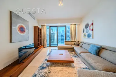 a living room with a couch and a tv at Trident Grand Residence 1 BDR plus Guest Bedroom, Dubai Marina in Dubai