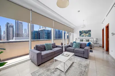 a living room with two couches and a large window at Elegant Studio with Burj Khalifa Skyline Views in Dubai