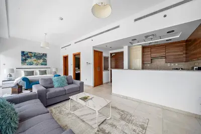 a living room with a couch and a kitchen at Elegant Studio with Burj Khalifa Skyline Views in Dubai