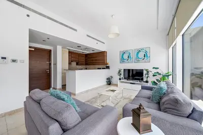 a living room with two couches and a kitchen at Elegant Studio with Burj Khalifa Skyline Views in Dubai