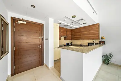 a kitchen with a wooden door and a counter at Elegant Studio with Burj Khalifa Skyline Views in Dubai