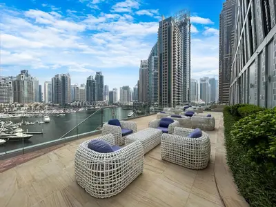 a balcony with chairs and a view of a city at 44th Floor Home at Cayan Tower with Panoramic Views in Dubai