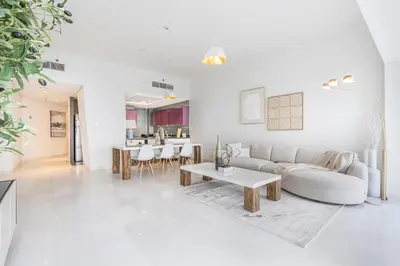 a white living room with a couch and a table at 44th Floor Home at Cayan Tower with Panoramic Views in Dubai