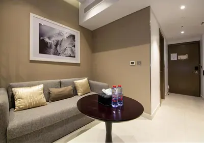 a living room with a couch and a table at Sleek & Stylish Studio in DAMAC Prive, Dubai in Dubai
