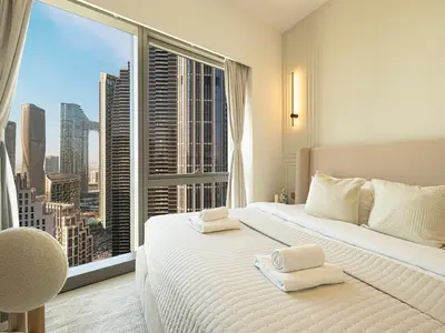 a bedroom with a large window with a view of a city at Grande Signature Residences by Prestige Nest in Dubai