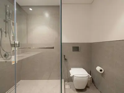 a bathroom with a toilet and a glass shower at Grande Signature Residences by Prestige Nest in Dubai
