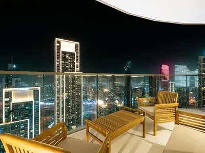 a balcony with a view of a city skyline at night at Grande Signature Residences by Prestige Nest in Dubai