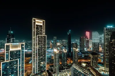 a city skyline at night with tall buildings at Grande Signature Residences by Prestige Nest in Dubai