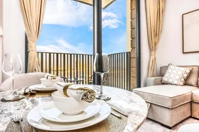 a table with plates and wine glasses on a balcony at FIRST CLASS Studio Stylish Comfort in Dubai