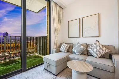a living room with a couch and a balcony at FIRST CLASS Studio Stylish Comfort in Dubai