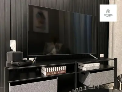 a black entertainment center with a large flat screen tv at KeyRock Living - 20th Floor Comfort at Zada in Dubai