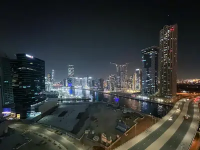 a city skyline at night with a river and buildings at KeyRock Living - 20th Floor Comfort at Zada in Dubai