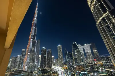 a view of a city skyline at night at Burj Khalifa View & Mall Entry in 3 Mins & Sleeps 3 Adults in Dubai