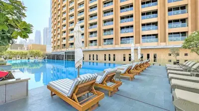 a row of lounge chairs in front of a building at Burj Khalifa View & Mall Entry in 3 Mins & Sleeps 3 Adults in Dubai
