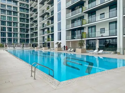 a large swimming pool in front of a building at GuestReady - Jumeirah Village haven with pool view in Dubai