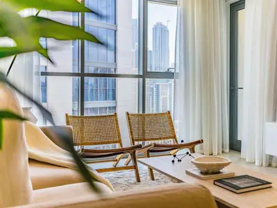 a living room with chairs and a large window at Chic Getaway with Balcony & Burj Khalifa View in Dubai