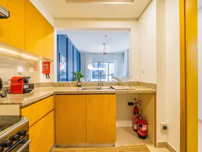 a kitchen with a sink and a large window at Chic Getaway with Balcony & Burj Khalifa View in Dubai
