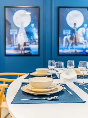 a dining room table with plates and wine glasses at Chic Getaway with Balcony & Burj Khalifa View in Dubai