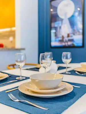 a table with a bowl and wine glasses on it at Chic Getaway with Balcony & Burj Khalifa View in Dubai