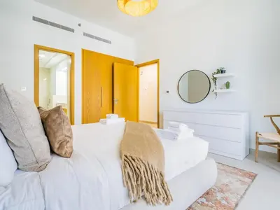a white living room with a white couch and a mirror at Chic Getaway with Balcony & Burj Khalifa View in Dubai