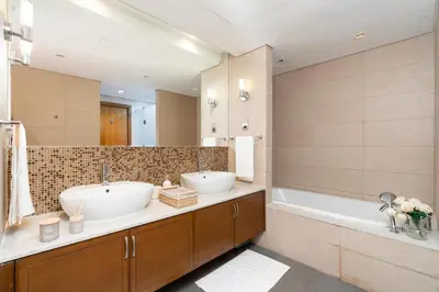 a bathroom with two sinks and a tub and a mirror at Marina Residence 6 - Luxurious Two Bedroom and Maid's - Lake and Sea View in Dubai