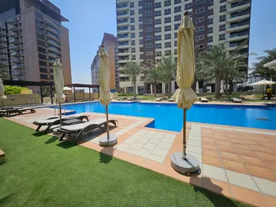 a swimming pool with yellow umbrellas and chairs next to a pool at Marina Residence 6 - Luxurious Two Bedroom and Maid's - Lake and Sea View in Dubai