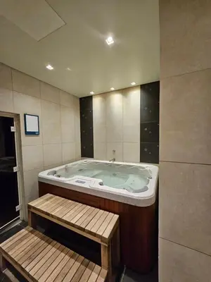 a jacuzzi tub in a bathroom with a wooden bench at Marina Residence 6 - Luxurious Two Bedroom and Maid's - Lake and Sea View in Dubai