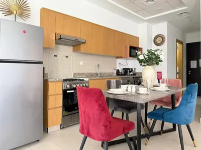 a kitchen with a table and chairs and a refrigerator at Burj Khalifa Panoramic view-1BR,4 guests, Downtown in Dubai