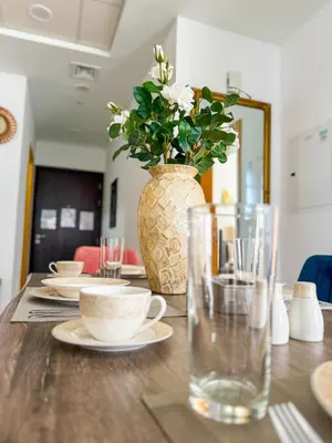 a wooden table with a vase with flowers in it at Burj Khalifa Panoramic view-1BR,4 guests, Downtown in Dubai