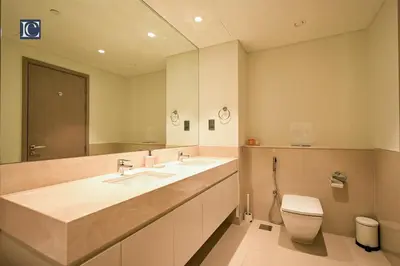 a bathroom with two sinks and a toilet and a mirror at Stylish Downtown Dubai Stay Act 1 Act 2 Tower 1 in Dubai