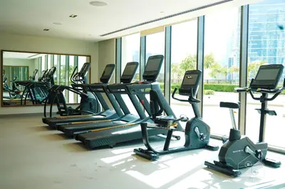 a gym with rows of treadmills and elliptical machines at Burj Crown Luxurious 2Bedroom Balcony in Dubai