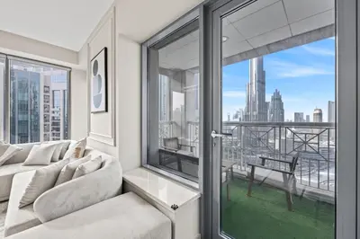 a living room with a couch and a large window at 29 Boulevard - Luxury 2BR Apartment with Burj Khalifa & Fountain View in Dubai