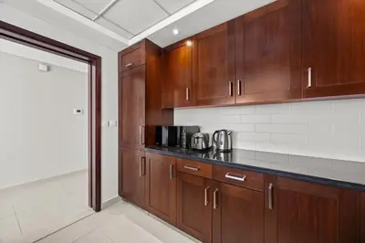 a kitchen with wooden cabinets and a counter top at 29 Boulevard - Luxury 2BR Apartment with Burj Khalifa & Fountain View in Dubai