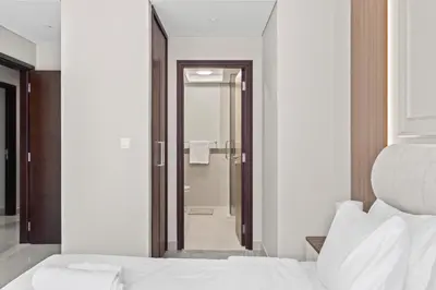 a bedroom with a bed and a walk in shower at 29 Boulevard - Luxury 2BR Apartment with Burj Khalifa & Fountain View in Dubai