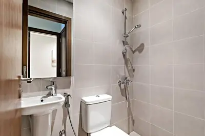 a bathroom with a shower and a toilet and a sink at Luxury 2BR Apartment Burj Khalifa View in Al Safa in Dubai