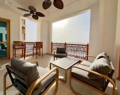 a living room with a balcony with chairs and a table at Luxury Spacious 2BR in Palm Jumeirah in Dubai