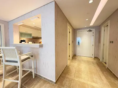 a hallway with a white chair and a table at Luxury Spacious 2BR in Palm Jumeirah in Dubai