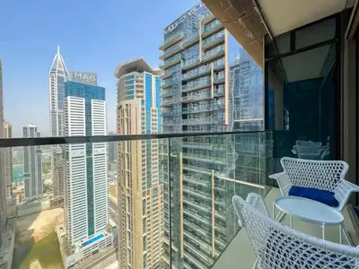 a balcony with chairs and a view of a city at Vogue Marina Gate near JBR Beach and Marina Mall, One Bedroom Apartment with Balcony and city skyline view, Access to all Amenities in Dubai