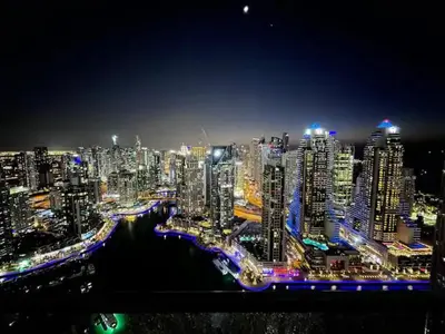a night view of a large city with buildings at Vogue Marina Gate near JBR Beach and Marina Mall, One Bedroom Apartment with Balcony and city skyline view, Access to all Amenities in Dubai