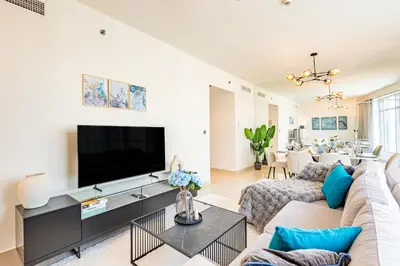 a living room with a couch and a tv at Luxury Stay - Private Jacuzzi - Infinity Pool - Marina & Sea Views - High Floor - Upgraded - Designer - Squash in Dubai